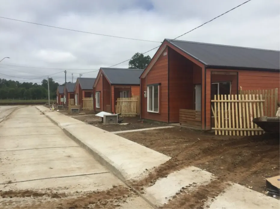 Conjunto habitacional rural con viviendas de madera y antejardines