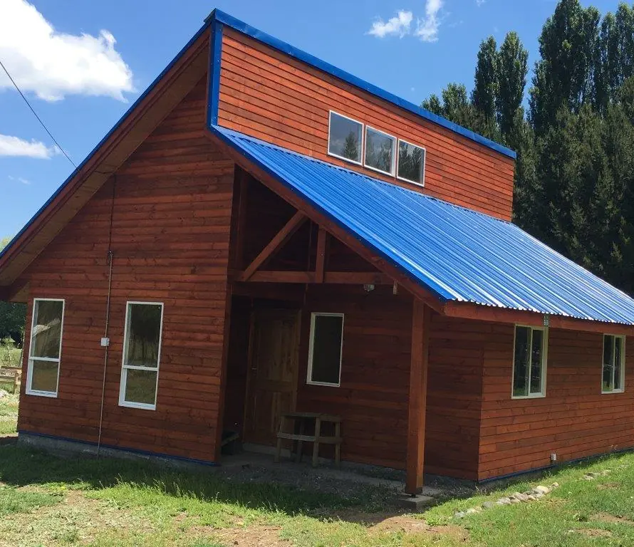 Casa DS10 de madera de dos niveles con techo de alta pendiente en el sur de Chile