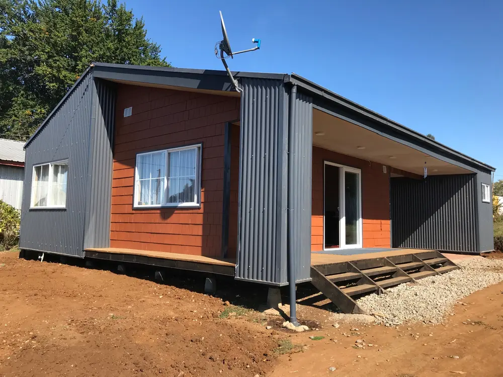 Casa de subsidio rural con revestimiento de madera y zinc en el sur